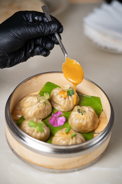 Steamed momos with a spoon of sauce